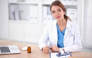 Homeopat sitter ved kontorpult